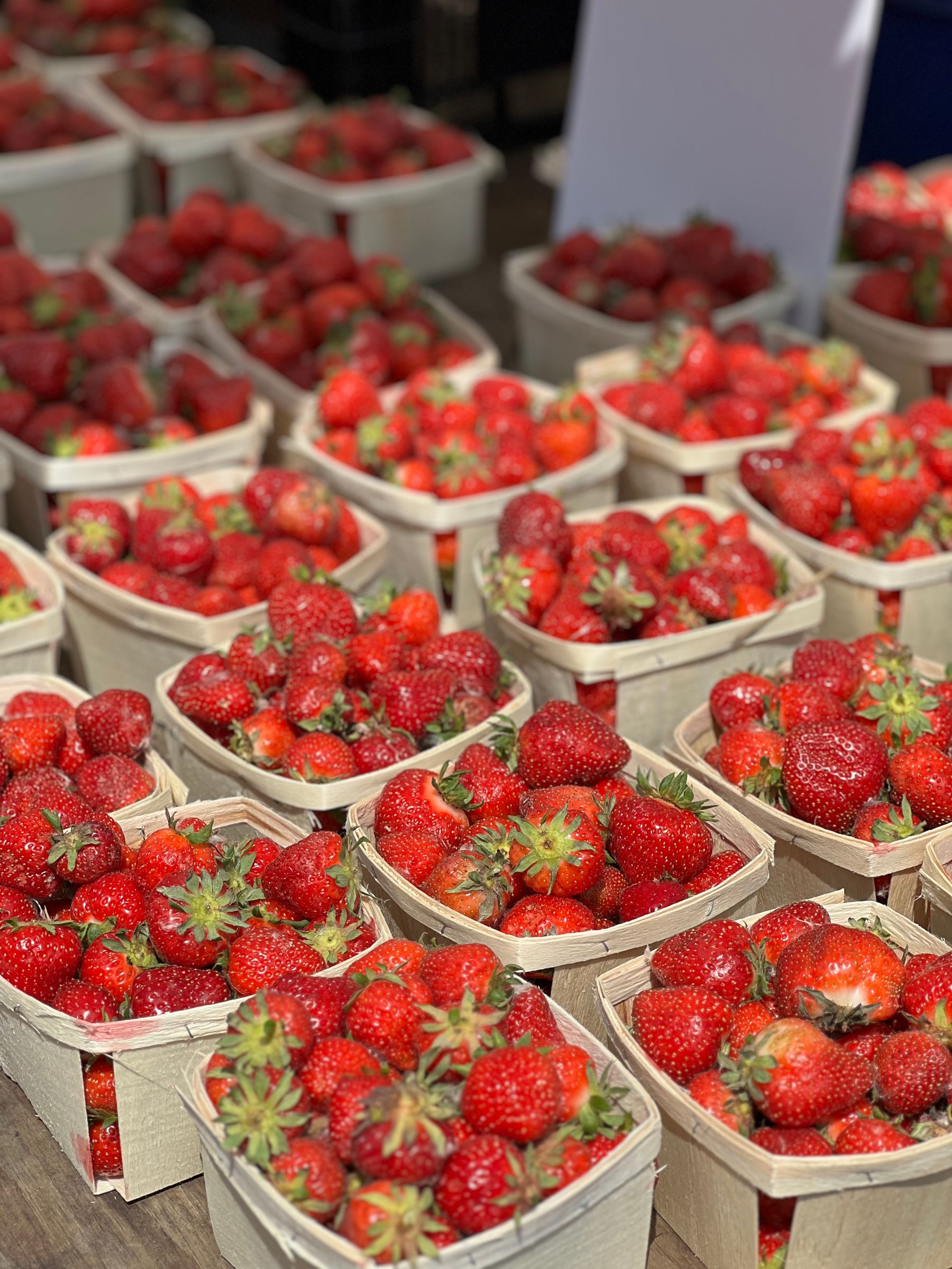 Wooden pints of fresh strawberries at a farm market