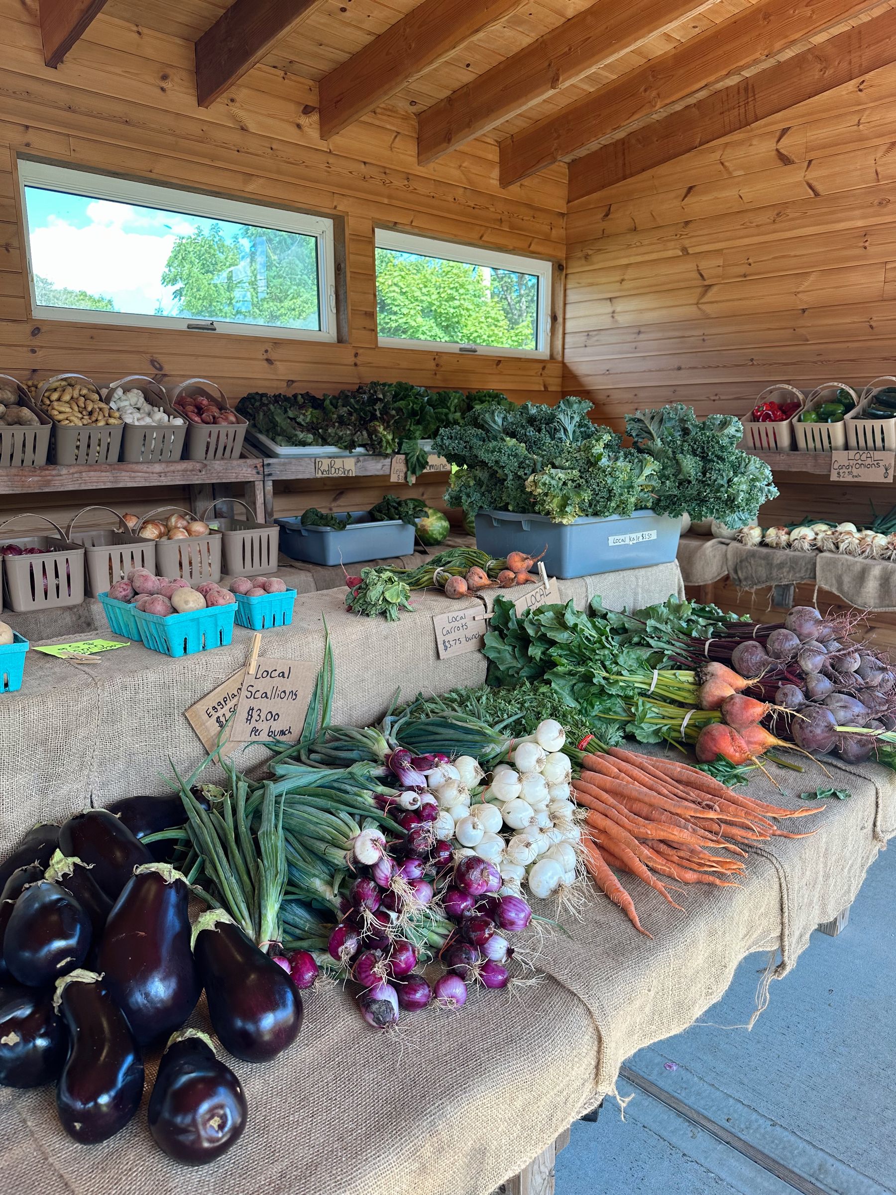 Wooden farm stand stocked with fresh local produce